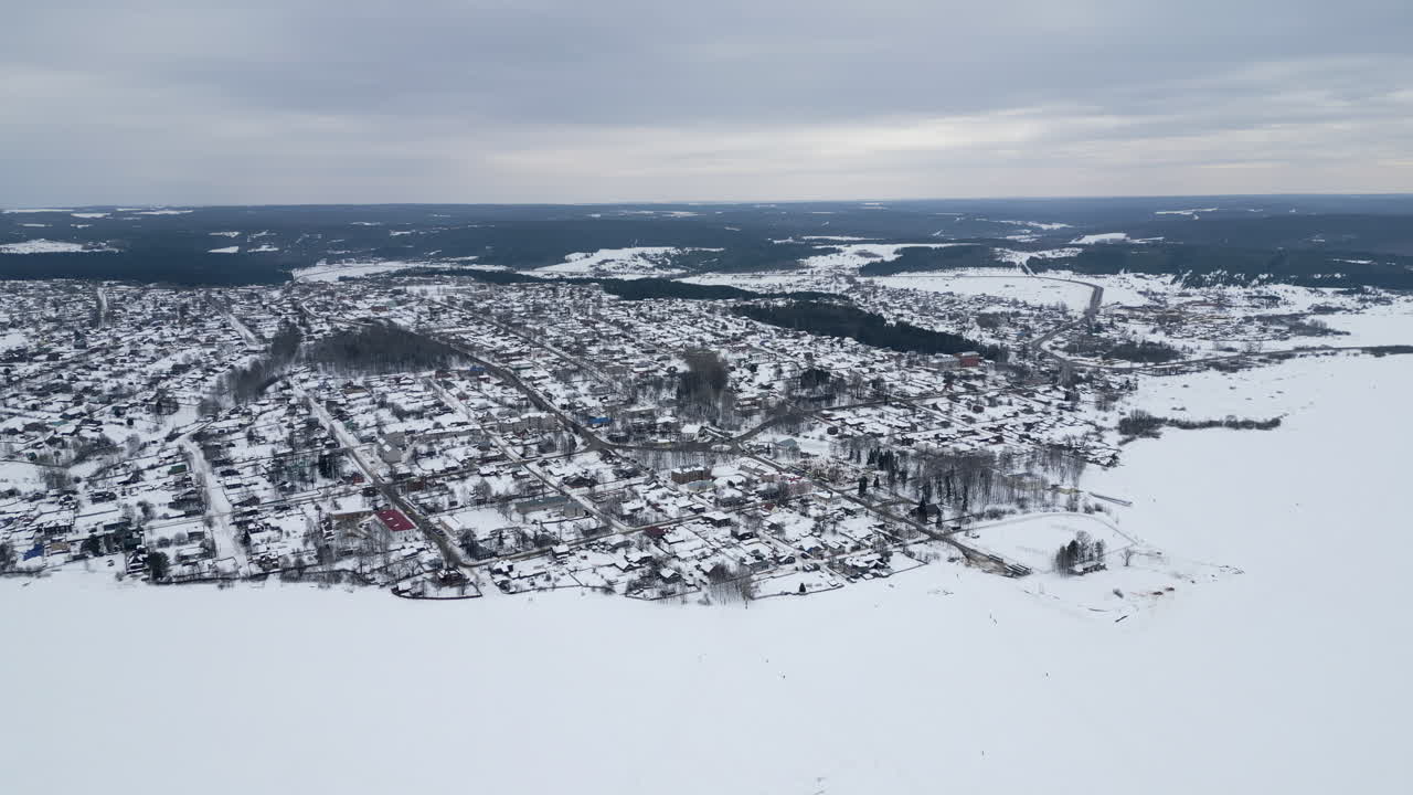 vista aérea de una ciudad nevada junto a un lago congelado