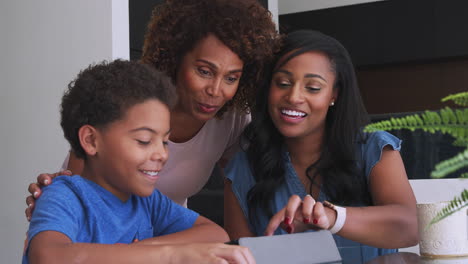 Abuela-Con-Madre-Ayudando-A-Su-Nieto-A-Hacer-La-Tarea-En-Una-Tableta-Digital