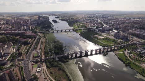 aerial view of mirror-like guadiana river with urban cityscape