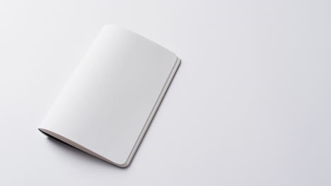 primer plano de un libro en blanco abierto con espacio de copia en un fondo blanco en cámara lenta