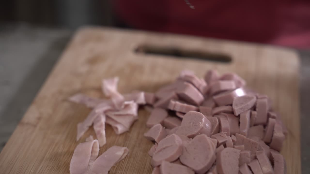 Guy chopping some delicious ham and sausage