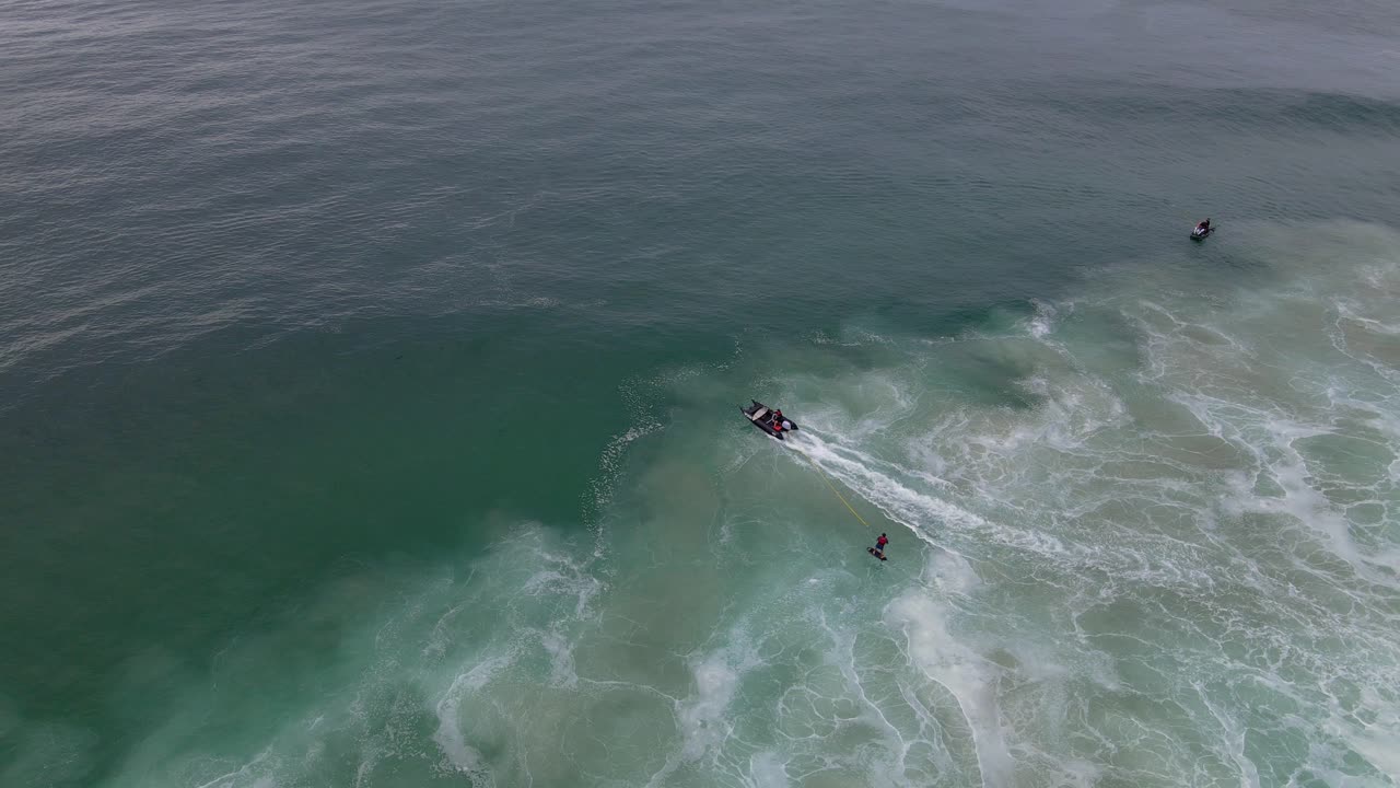 hidroala surfista tirado por un barco en la playa de sharpes - surf en skennars head - nsw, australia - drone aéreo