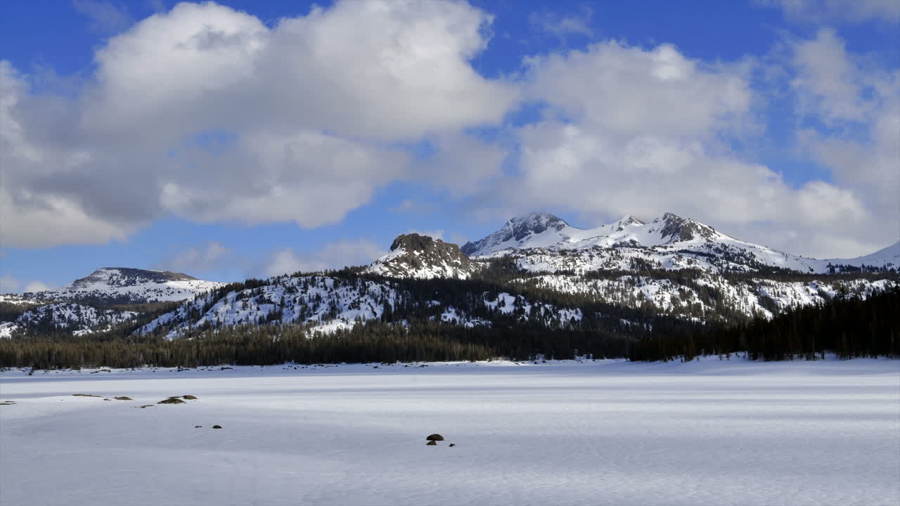 얼어붙은 호수와 산 위로 부는 구름의 시간 경과