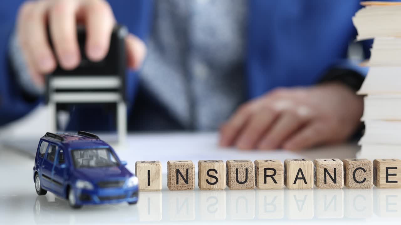 Agent stamps car insurance document closeup