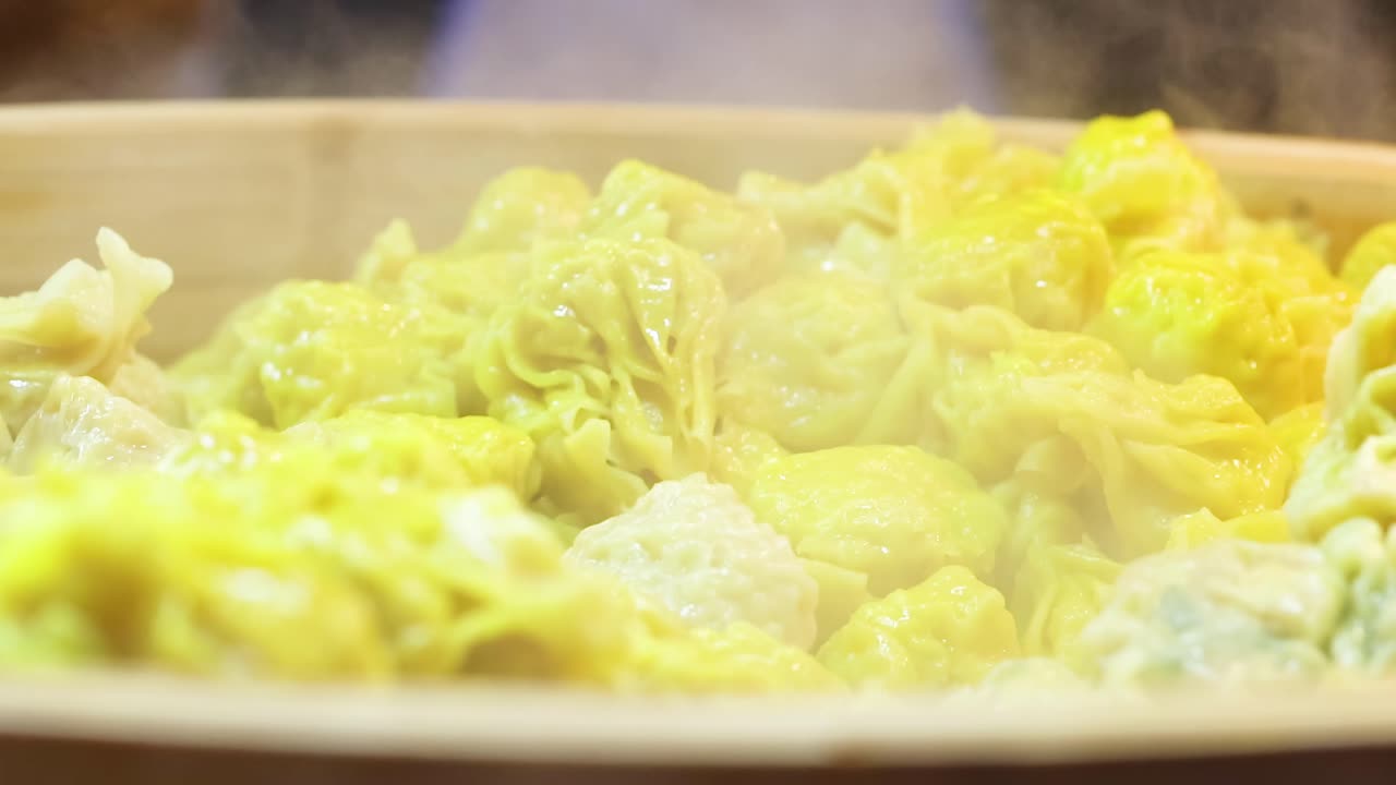 Close-up of yellow dumplings steaming in a bamboo steamer, showcasing their texture and vibrant color.