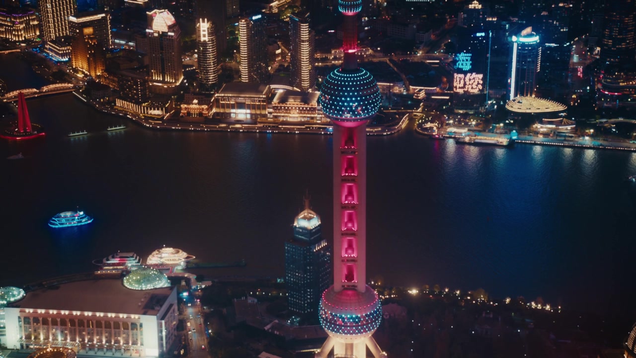 Menara Oriental Pearl yang ikonik diterangi pada malam hari di Lujiazui, distrik Pudong, Shanghai. Bola-bola khas menara memancarkan cahaya merah muda dan biru, menjulang di atas tepian Sungai Huangpu.