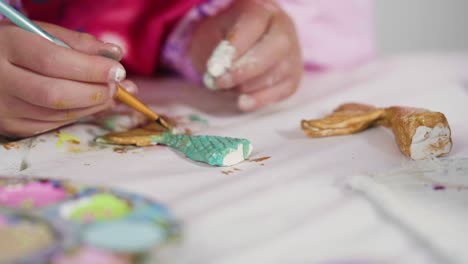 una niña pintando colas de sirena