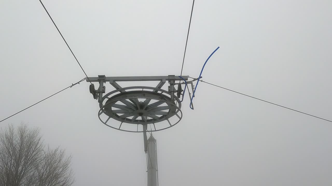 elementos del mecanismo de transporte - mecanismo de elevación de esquí en la pista de esquí de la montaña en un tiempo de niebla