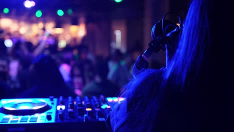 dj performing at a nightclub with a crowd and colorful lights