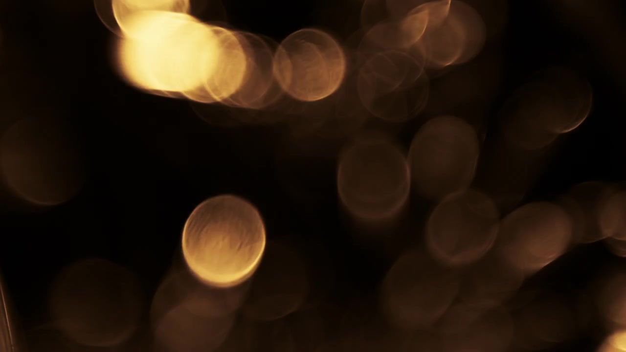 Luci bokeh dorate astratte e luminose su sfondo scuro