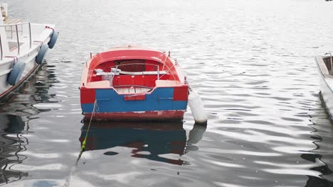 pequeño barco rojo y azul en un muelle