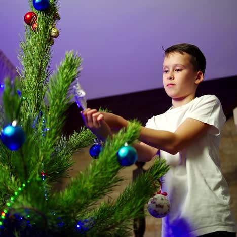 boy decorates christmas tree