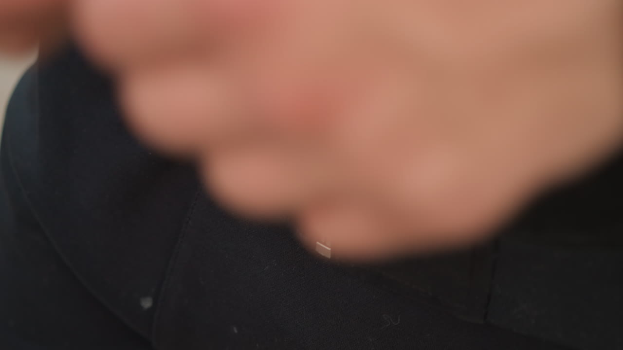 재킷을 정리하는 부드러운 남성, 도시 풍경 속 재킷 지퍼를 채우는 남성의 손 클로즈업, 도시를 배경으로 재킷 지퍼를 조심스럽게 올리는 백인 남성의 손을 세밀하게 묘사한 이미지