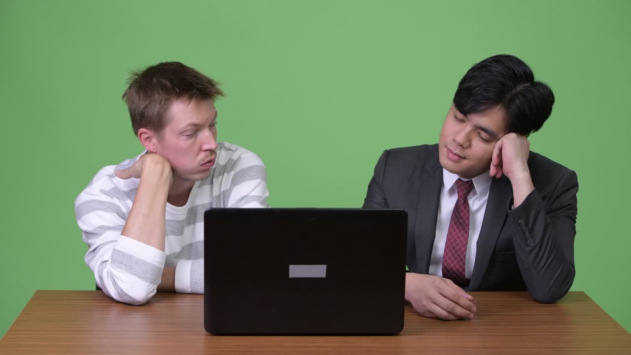 젊은 아시아 사업가와 젊은 스칸디나비아 사업가가 노트북으로 함께 일하고 있습니다.