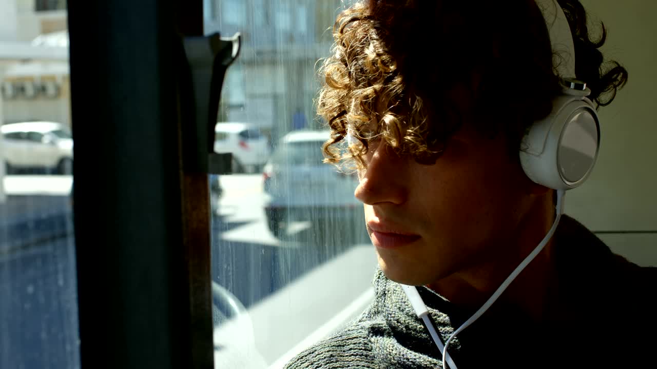 Pendolare che ascolta musica in cuffia mentre viaggia in autobus 4k