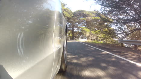 side shot of silver car driving in california