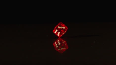 Red-plastic-dice-revolving-on-black-background