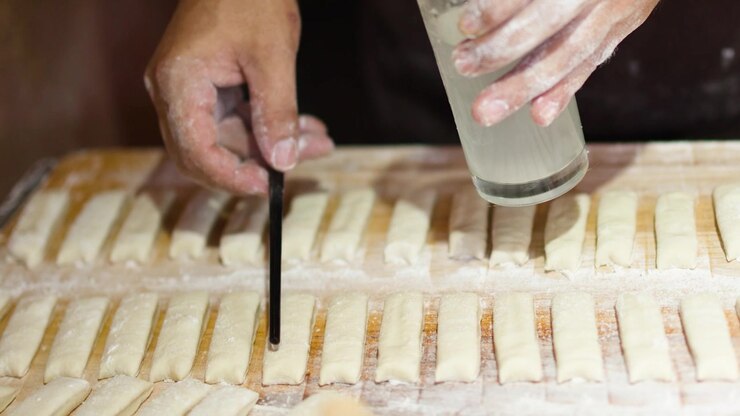 Baker Preparing Dough Strips for Traditional Pastry