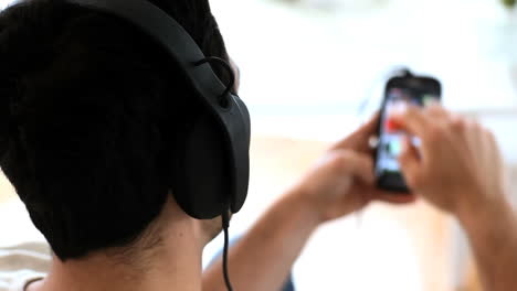 man moving his head while listening to music with his phone