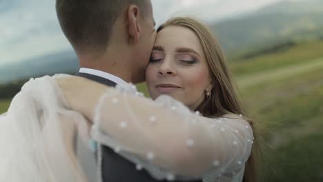 groom with bride having fun on a mountain hills. wedding couple hugging