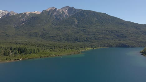 Aerial-pan-right-of-Epuyen-lake-with-mountains-covered-in-pine-tree-woods,-Patagonia-Argentina