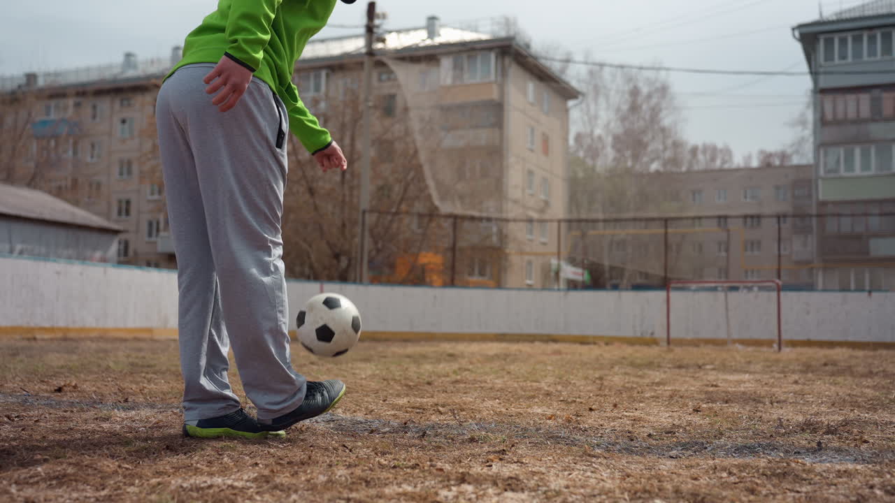 Pies que driblan con habilidad, imagen detallada que muestra movimientos precisos del pie con calzado desgastado, captura enfocada de un individuo que guía expertamente el balón por un terreno resbaladizo vestido de forma casual