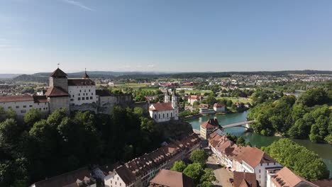 aerial view of aarburg castle and church above the aare river with swiss countryside in the background