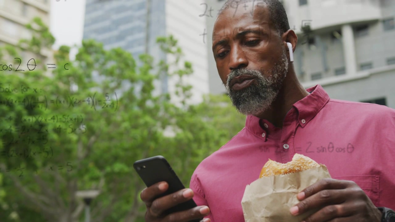 Mature man standing park, scrolling phone and eating, causing math graphs building up for education