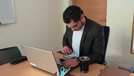 analyst using calculator and laptop for data