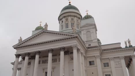 La-Gran-Catedral-De-Helsinki-Vista-Desde-El-Frente-A-Nivel-Del-Suelo,-Toma-En-Movimiento-De-Este-Famoso-Edificio-Alto-Y-Blanco