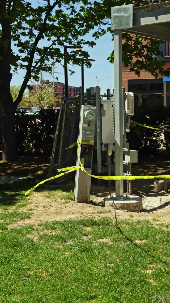 Lavori di costruzione in corso vicino a un contatore elettrico in un'area parco, con barriere e nastro di segnalazione intorno