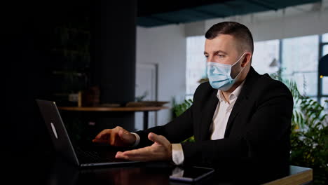 man wearing surgical mask working at computer. office work in the conditions of pandemics.