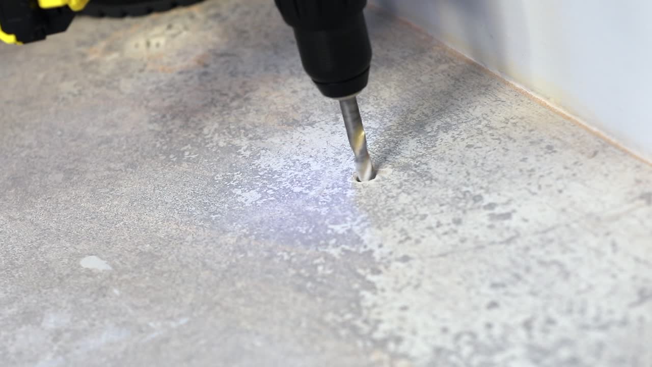 노동자는 작동하는 전기 드릴로 땅에 구 ⁇ 을  ⁇ 습니다.