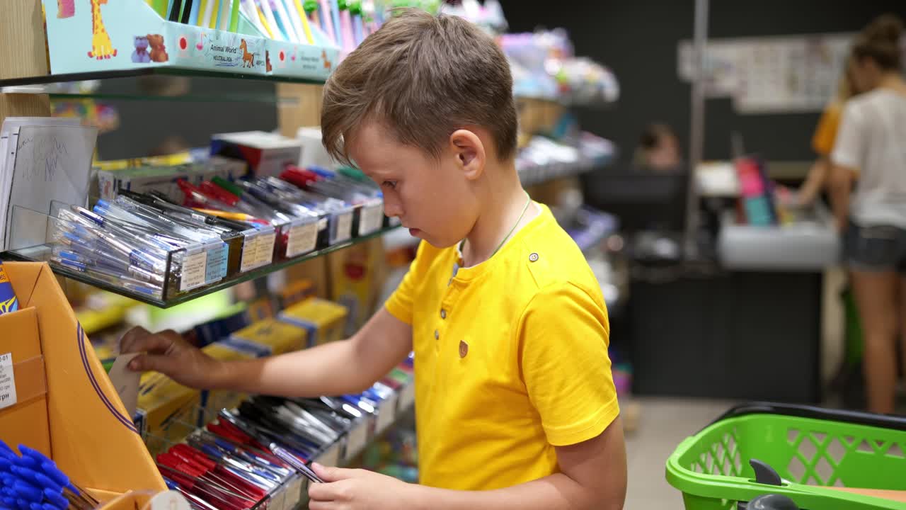 Child with school stationery. Boy shopping for back to school