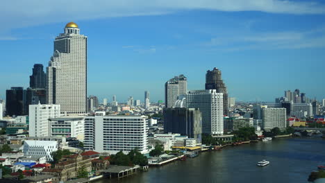 lapso de tiempo del tráfico fluvial frente al edificio de la torre estatal y su cúpula dorada en el centro de bangkok, tailandia