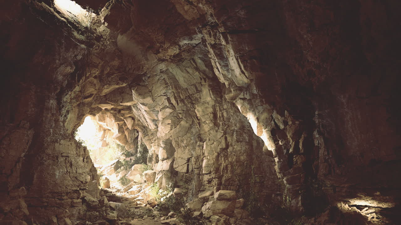 Exploring a hidden cave illuminated by natural light in a remote location