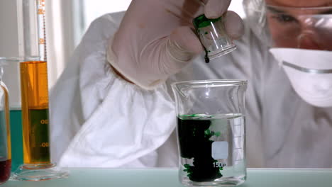 scientist mixing and pouring liquids in beaker