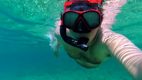 man snorkeling in clear turquoise water