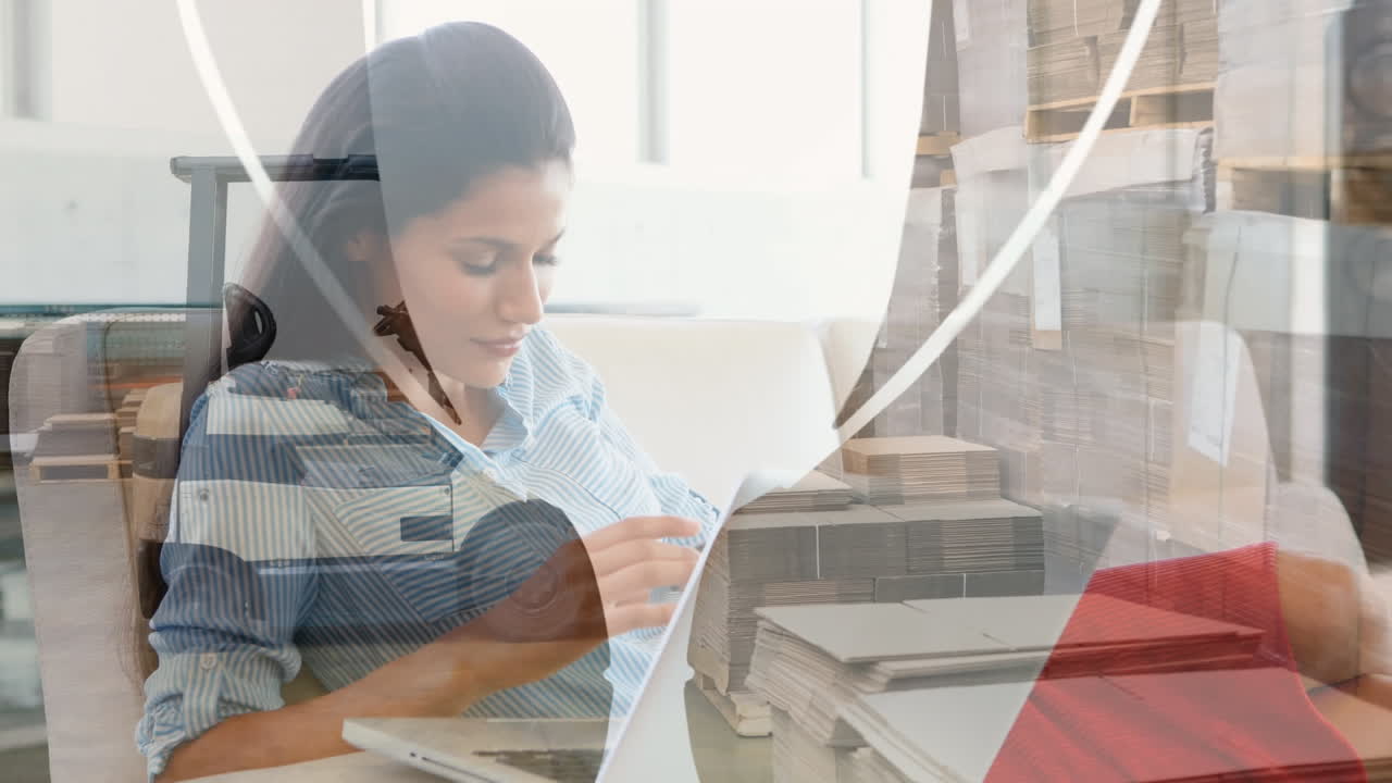 animación de un almacén sobre una mujer de negocios biracial usando una computadora portátil.