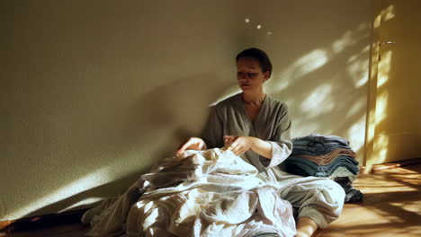 woman sitting with laundry in sunlight