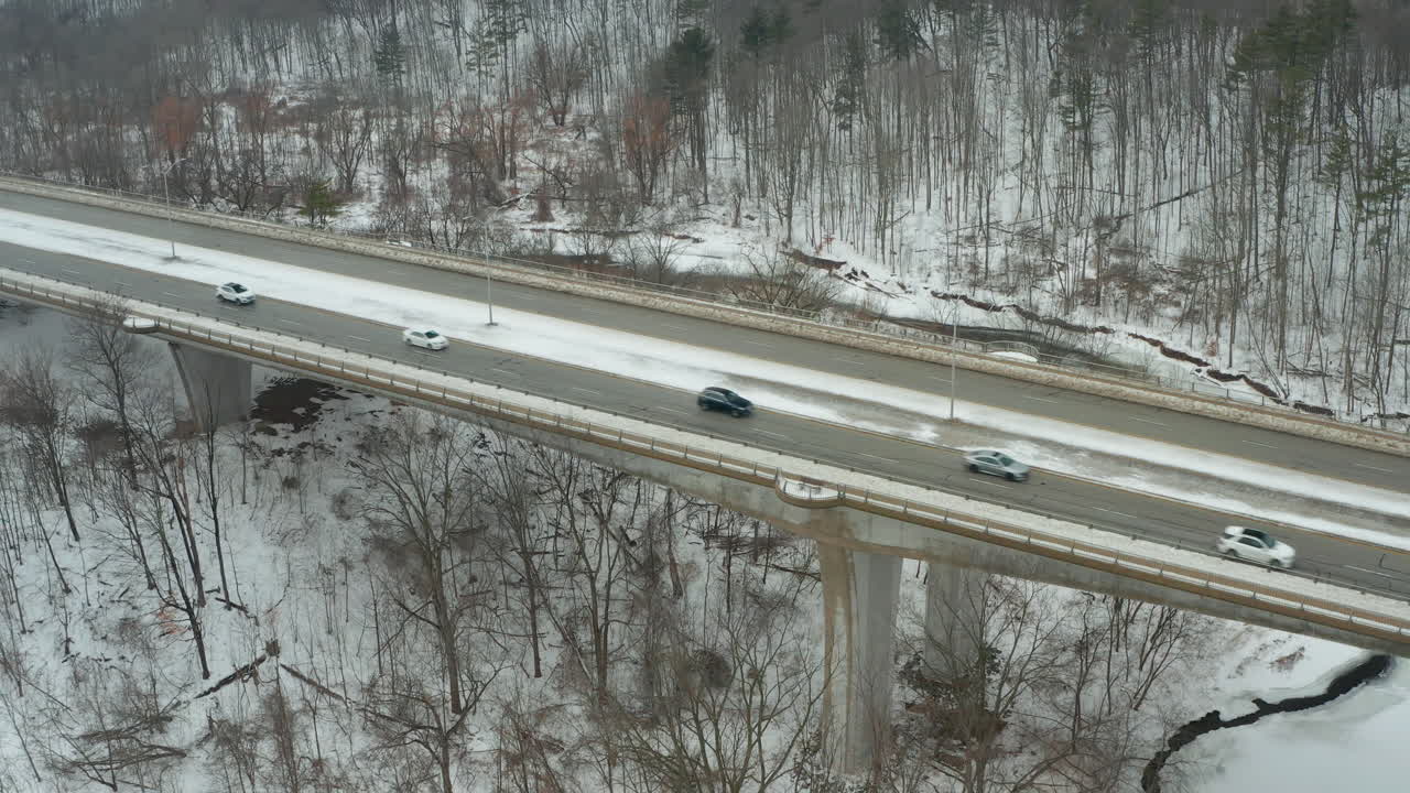 자동차가 가로질러 운전할 때 눈 덮인 다리의 조감도