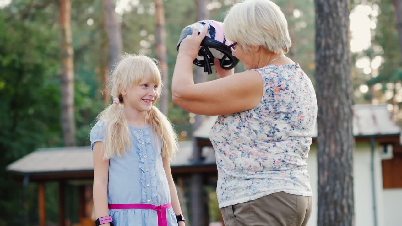 mujer mayor se pone un casco protector para el concepto de su hija - cuidado y seguridad video 4k