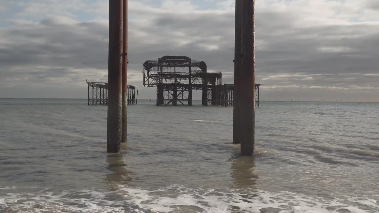 famous burnt pier in brighton city england uk. columns on the beach and calm sea