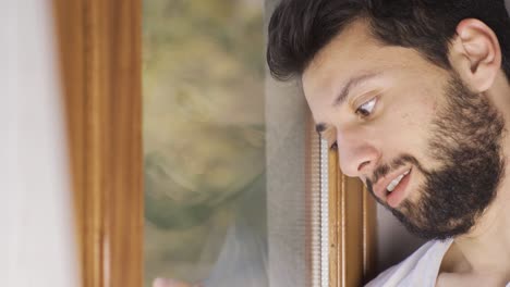 mentally ill man looking out the window. schizophrenia disease.