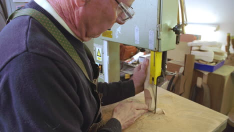 bespoke shoemaker shaping wooden last for shoe using jigsaw