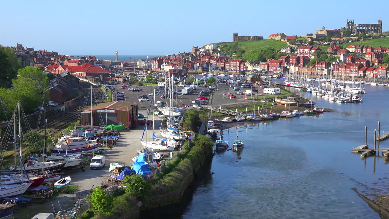 una toma de establecimiento de la ciudad de whitby inglaterra con el puerto y la catedral de la abadía distante 1
