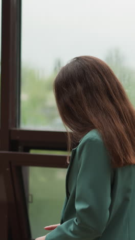 pensive businesswoman walks along glass terrace. trader broken by unexpected stock market crash suffers in office. difficult situation in company