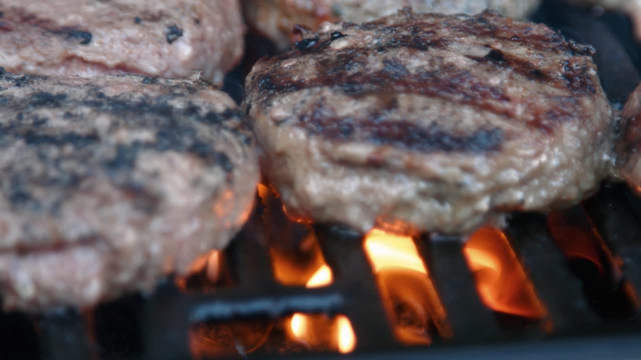 Hamburger di manzo grigliati alla fiamma al barbecue.