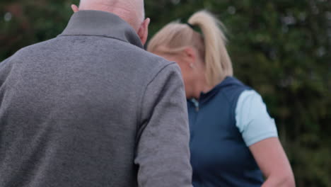 A woman and a senior man on a golf course