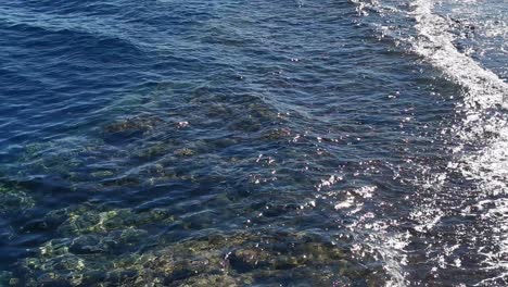 uitzicht op zee golven, rots en zand. zee kust water achtergrond